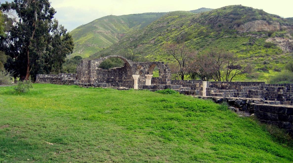 A stone structure in a grassy field with Choquequirao in the background

Description automatically generated
